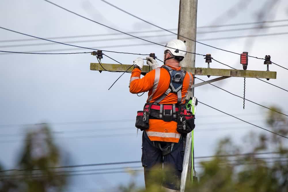Technician working on electrical power lines at a utility pole