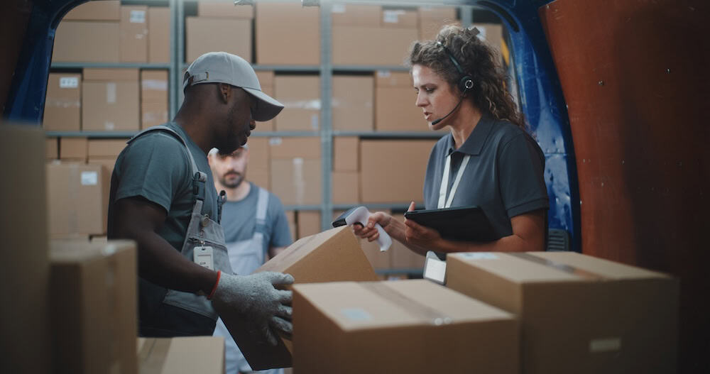 Logistics staff inspecting boxes and verifying shipping details