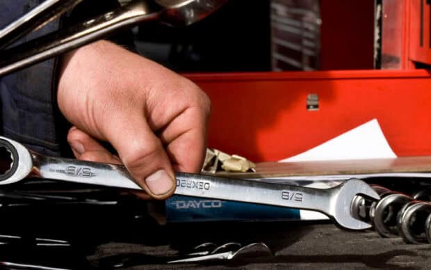 A hand taking a wrench from a tool chest.