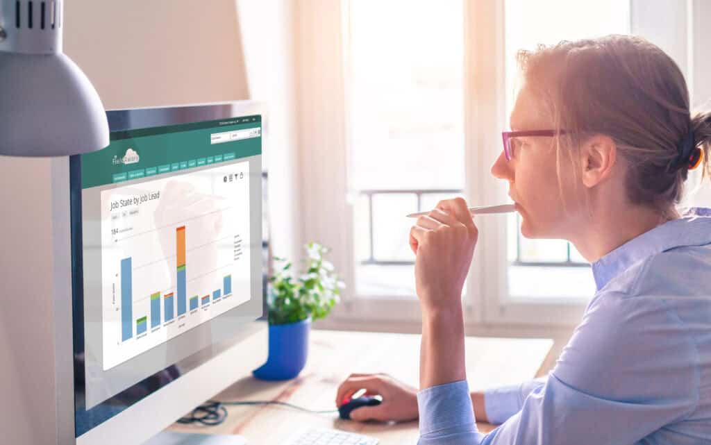A woman looking at charts on a monitor.