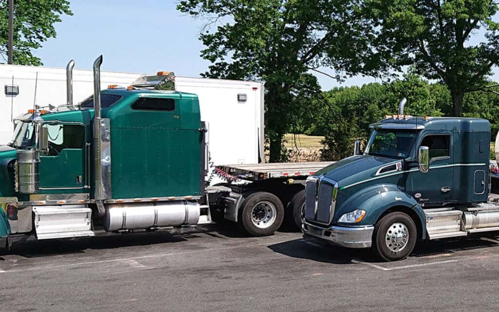 Semi-trucks parked in a staggered line at a rest area.