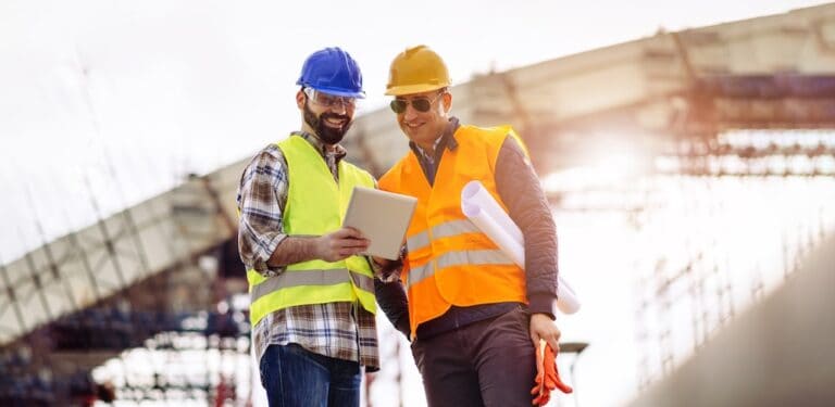 Construction Workers Looking at Tablet on Jobsite