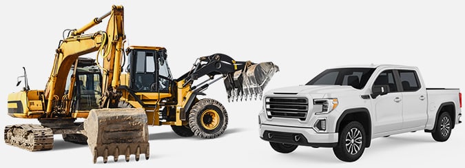 a pickup truck next to a excavator and backhoe