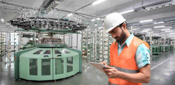 A utility worker at a plant checking a tablet.